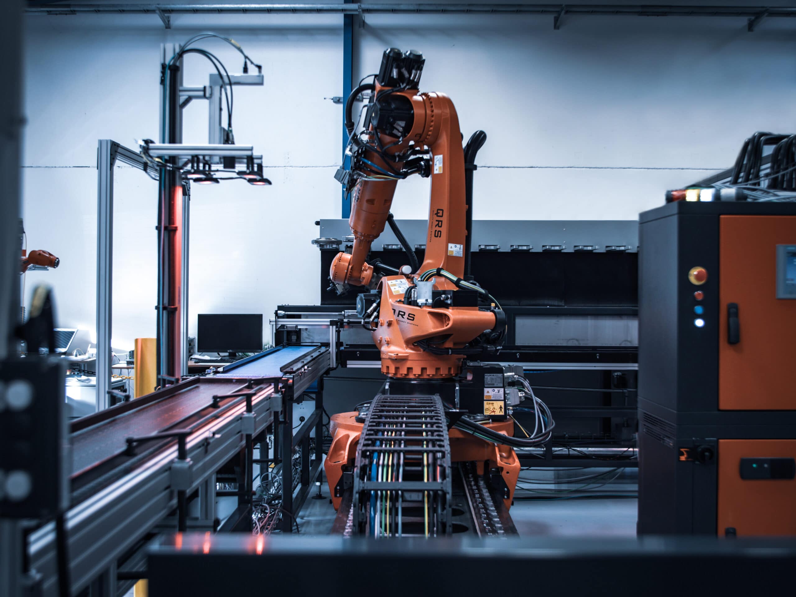 Orange Kuka robot on a track in a robotic automated production plant