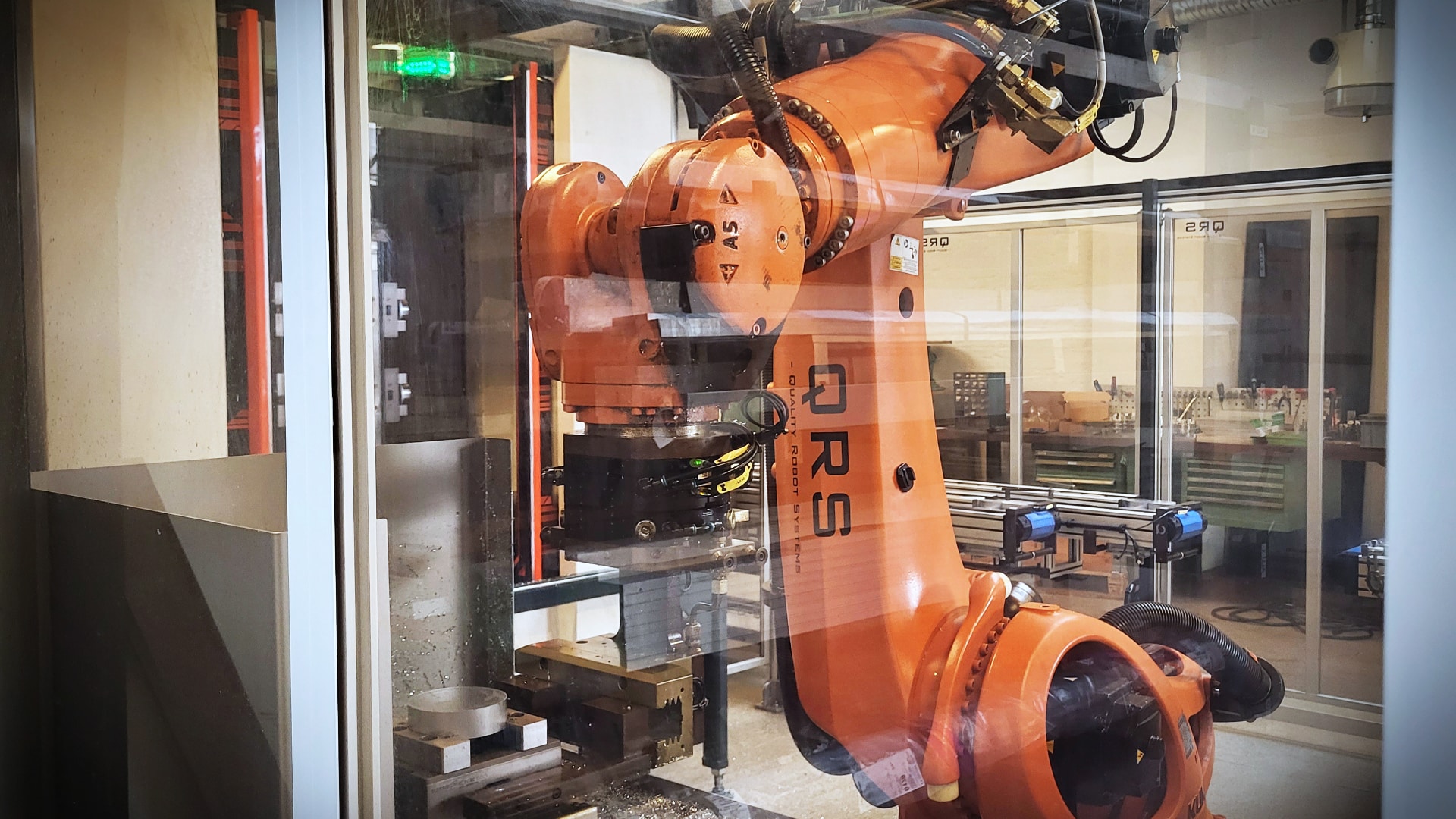 Complex QRS robotic cell consisting of a Kuka KR120 robot operating the clamping station for screw jacks. In the background is the Mazak HCN-4000 milling machine with cube for vice, which the robot operates.